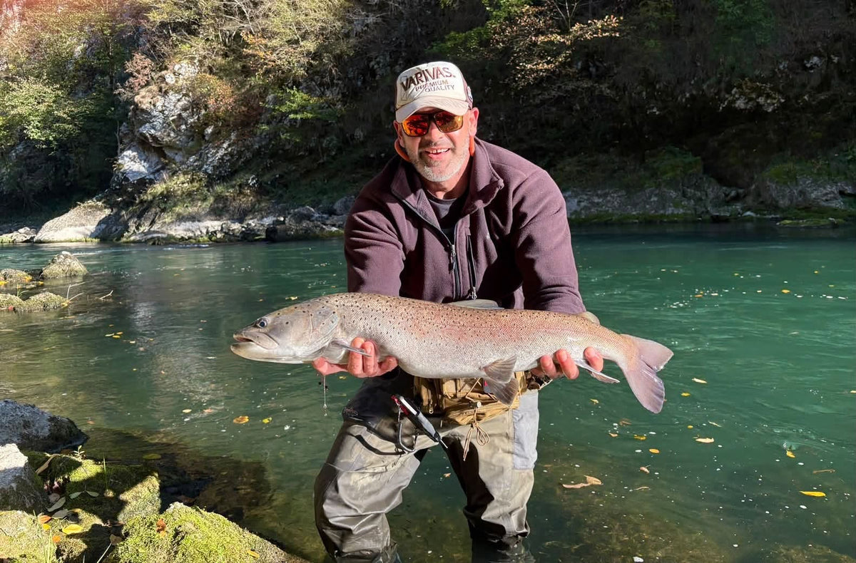 Fiskare visar upp sin fångst vid en smaragdgrön flod på fiskeresa i Bosnien