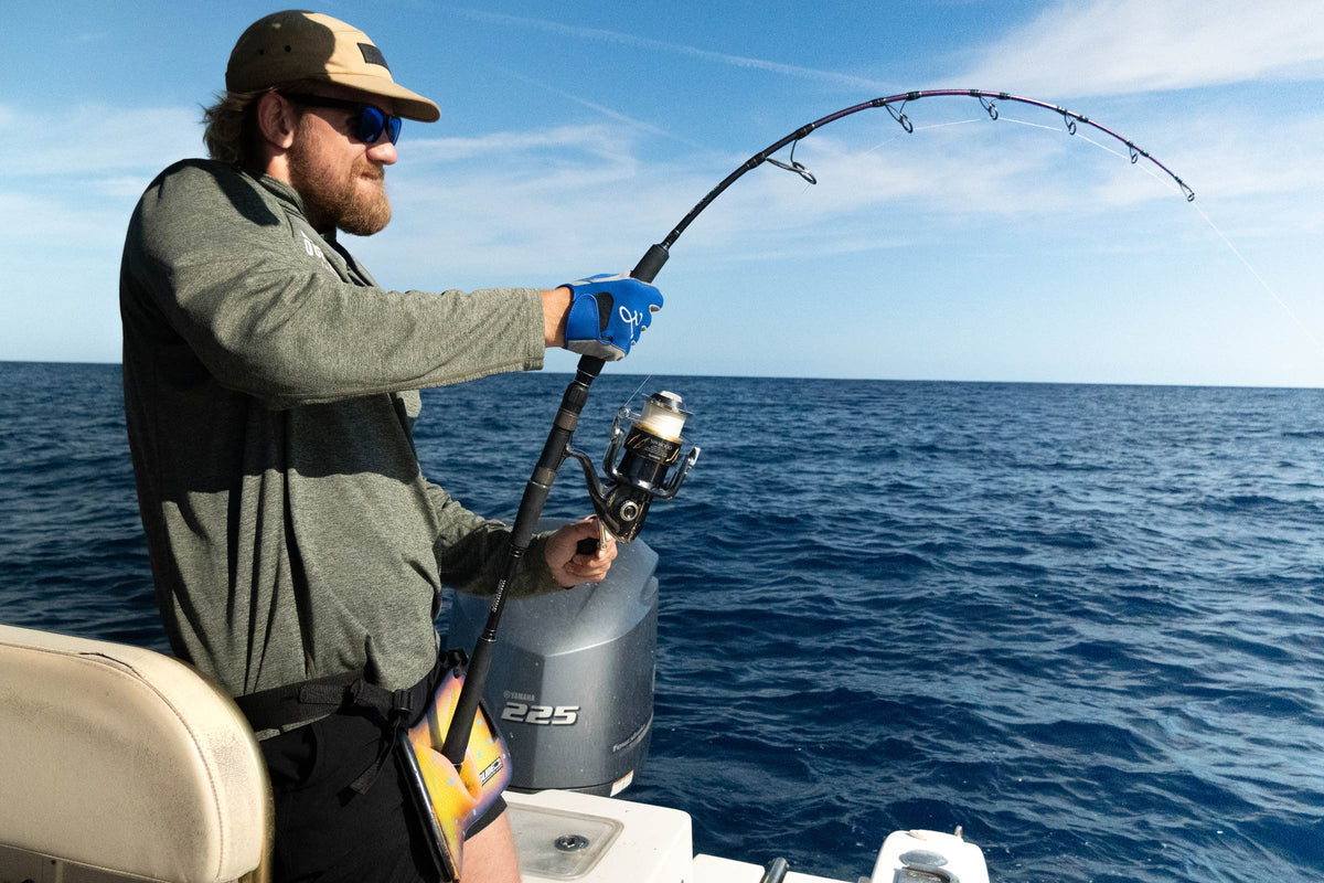 Fiskare drillar en tonfisk från aktern på en fiskebåt under guidat havsfiske i Spanien